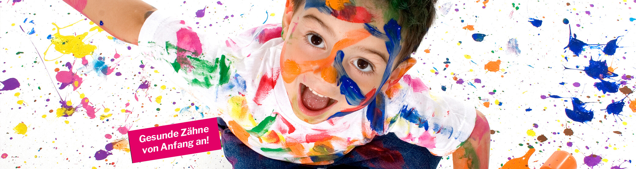 strahlendes Kind, Ansicht von oben, mit bunten Farben gespränkelter Raum